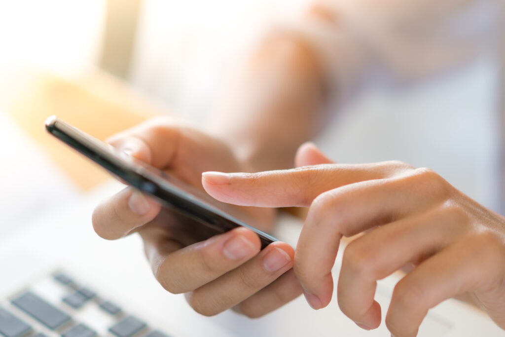 Woman using mobile phone at desk.